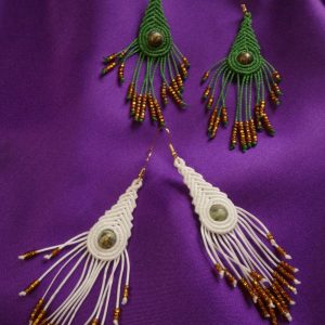 «Χειροποίητα μακραμέ σκουλαρίκια που θυμίζουν φτερά παγωνιού, σε πράσινη και λευκή κηροκλωστή με μελί γυάλινες χάντρες και ατσάλινα γαντζάκια»