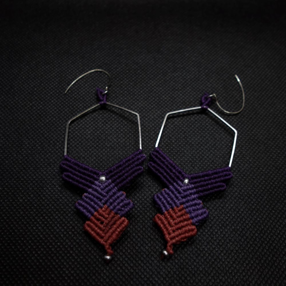 Ζευγάρι χειροποίητα μακραμέ σκουλαρίκια σε μωβ και ροζ αποχρώσεις με ασημί εξάγωνο κρίκο σε μαύρο φόντο