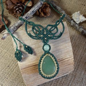 Χειροποίητο πράσινο μακραμέ κολιέ με πέτρα αβεντουρίνης σε σχήμα δάκρυ και χρυσαφένιες χάντρες, τοποθετημένο πάνω σε ξύλινο rustic φόντο.