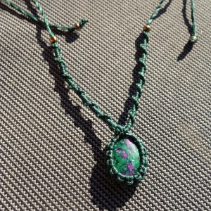 Πράσινο μακραμέ κολιέ με πέτρα Ρουμπίνι σε Ζοισίτη και χρυσές χάντρες σε γκρι φόντο.