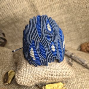 Χειροποίητο μακραμέ βραχιόλι σε μπλε και γκρι με μοτίβο που θυμίζει μάτια και κλείσιμο αυξομείωσης