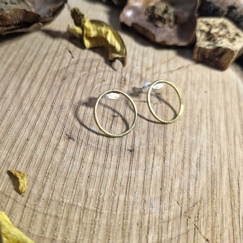 Χειροποίητα ορειχάλκινα σκουλαρίκια κύκλοι σε φυσικό ξύλινο φόντο με minimal αισθητική