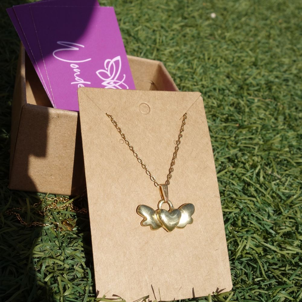Χειροποίητο ορειχάλκινο κολιέ με φτερωτή καρδιά και ατσαλινή αλυσίδα σε φυσικό φως