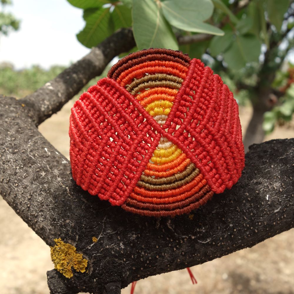 Χειροποίητο μακραμέ βραχιόλι με κυκλικό σχέδιο σε κόκκινες και γήινες αποχρώσεις, με αυξομείωση