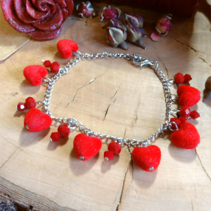 Χειροποίητο βραχιόλι με ατσάλινη αλυσίδα, βελούδινες κόκκινες καρδιές και κόκκινα κρυσταλλάκια σε ξύλινο φόντο