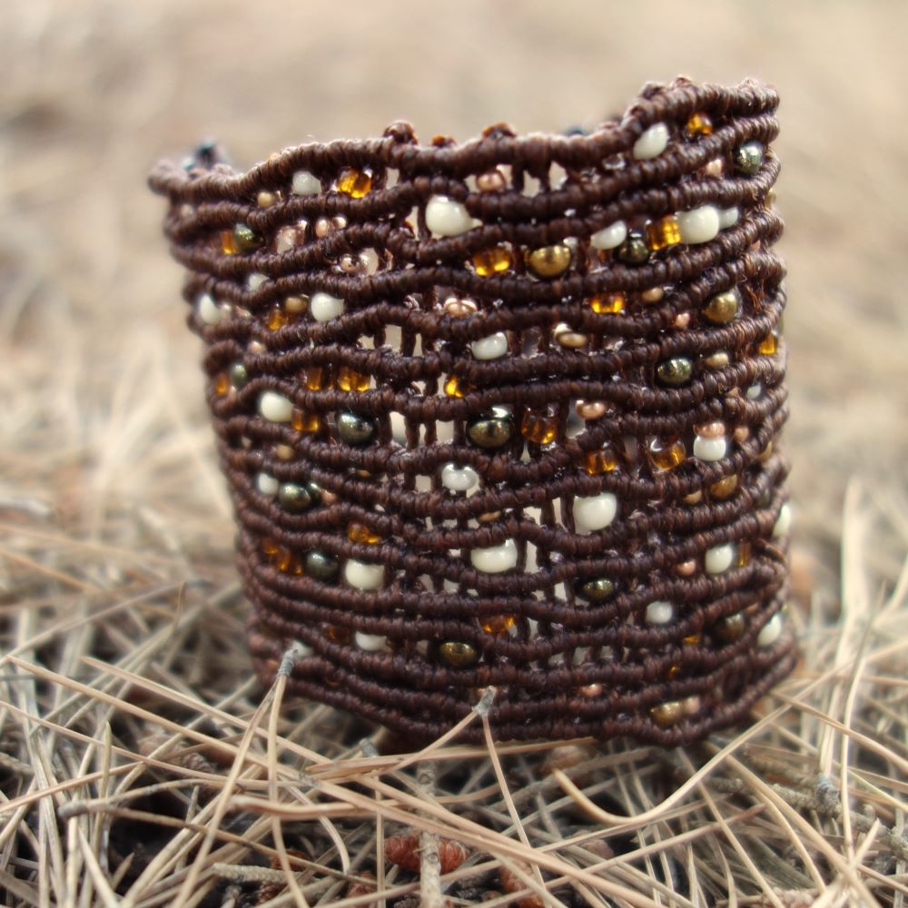 Χειροποίητο μακραμέ βραχιόλι σε καφέ με αφηρημένη σύνθεση γυάλινων και μεταλλικών χαντρών σε μελί και γήινες αποχρώσεις