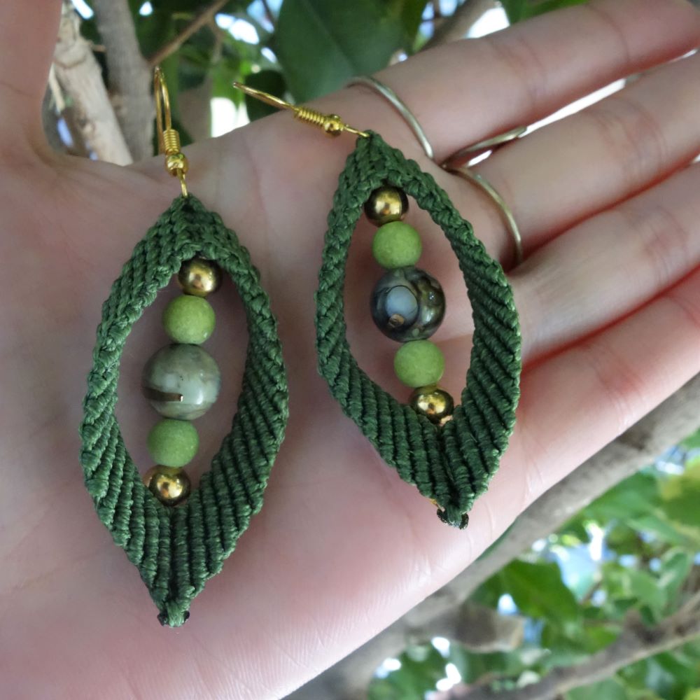 Χειροποίητα μακραμέ σκουλαρίκια σε λαδί με διαφορετικές χάντρες και χρυσά στοιχεία.